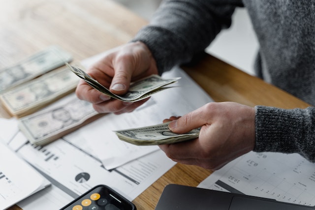 person%20counting%20cash%20with%20stats%20spread%20out%20on%20their%20desk person%20counting%20cash%20with%20stats%20spread%20out%20on%20their%20desk
